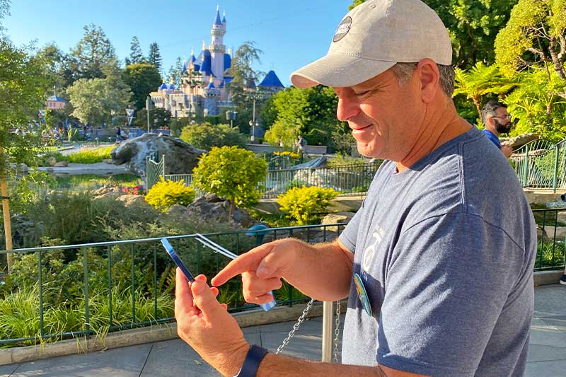 Maximize Your Time at Disneyland - Man uses Genie+ on phone