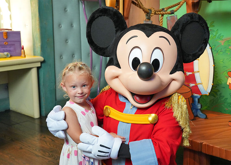 Our Top Tips for Visiting Mickey's Toontown with Kids - Girl poses with Mickey