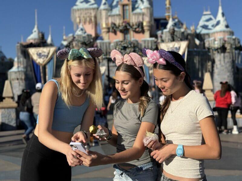 Which Rides Are Available on Lightning Lane at Disneyland? - Teens select Lighting Lanes on phone