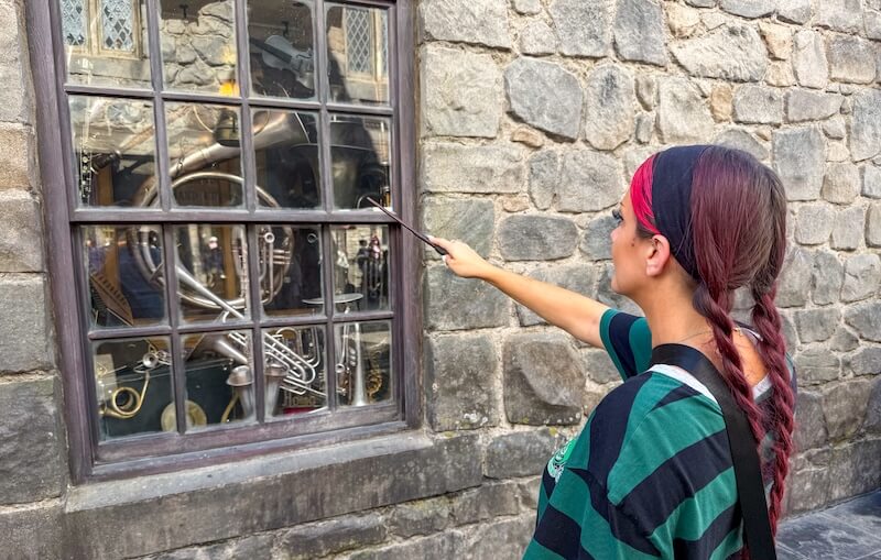 Choosing a Wand at the Wizarding World in Universal Studios Hollywood - guest using wand at interactive spell location
