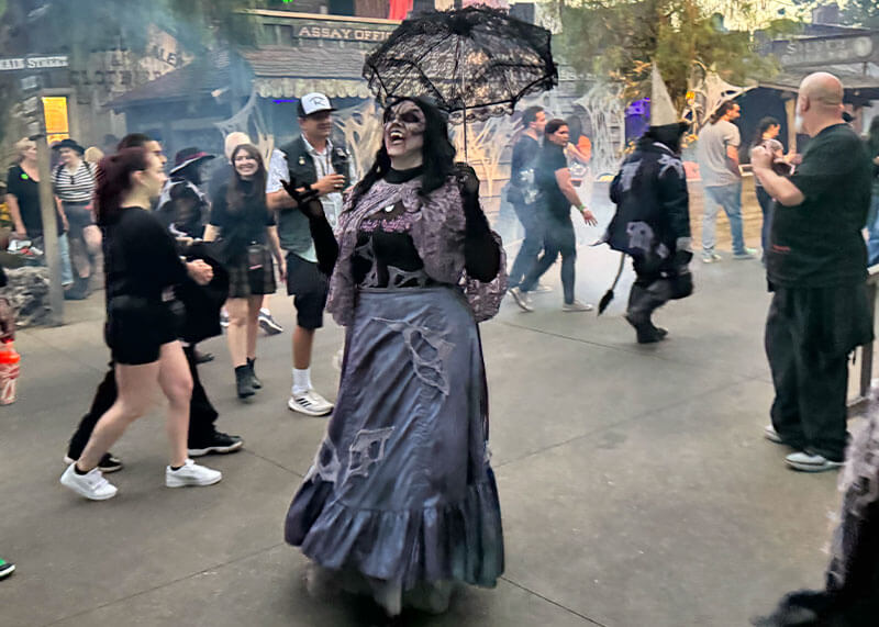 Your Ghoulish Guide to Knott’s Scary Farm - Woman in ghost Town with umbrella