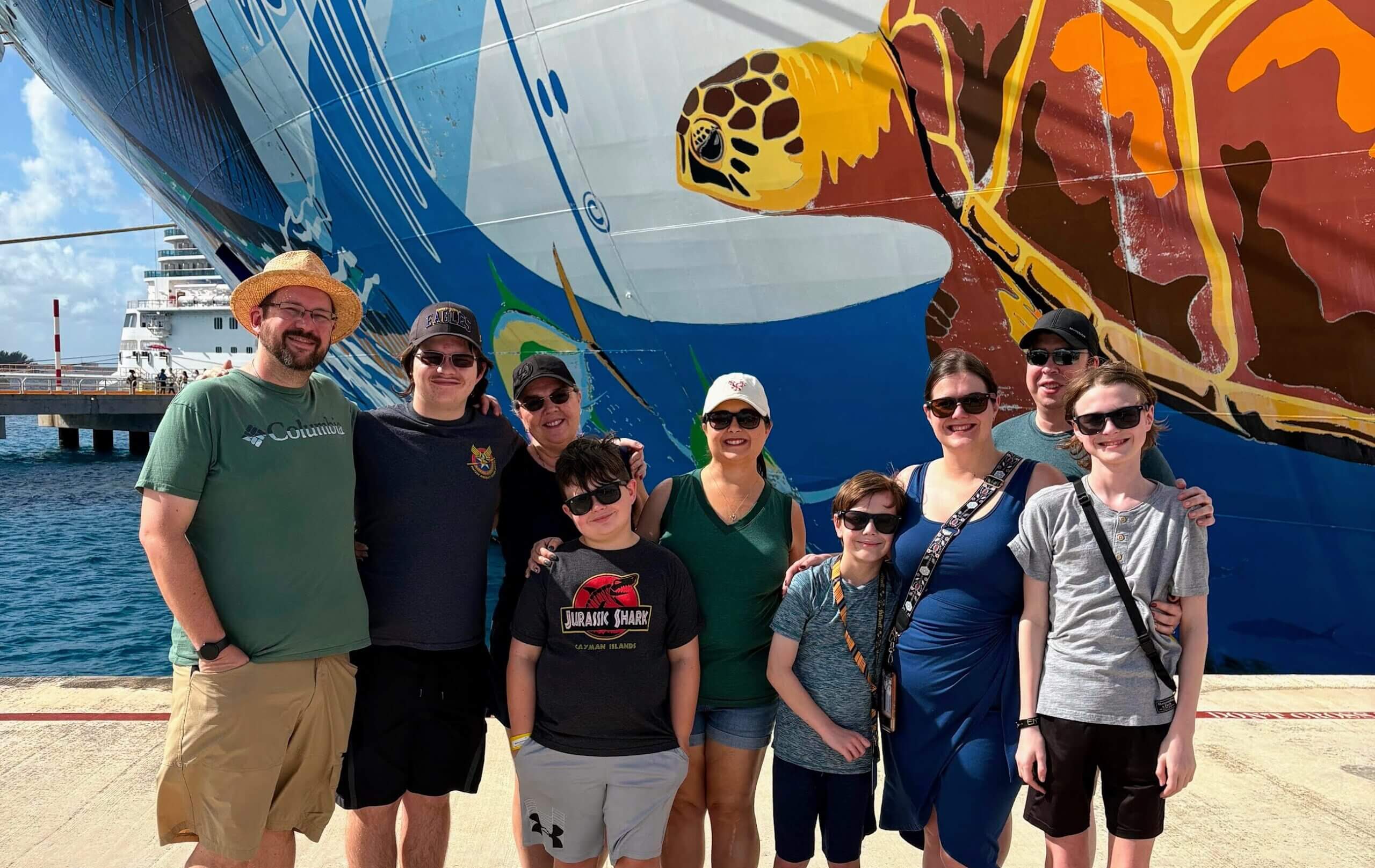 Norwegian Escape - Family poses in front of Norwegian Cruise Ship Escape in Puerta Maya, Mexico