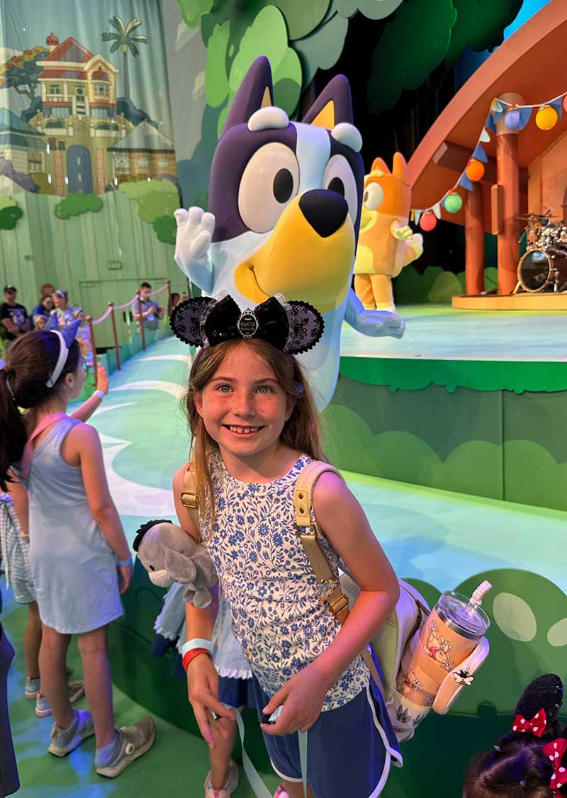 Bluey at Disneyland - Girl standing in front of Bluey