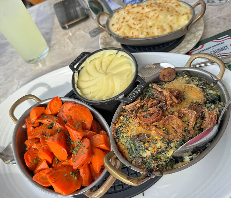 Sides at Gordon Ramsay at The Carnaby, including creamed spinach, carrots and potatoes au gratin