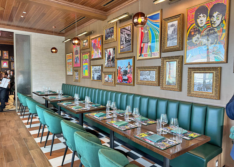 Interior at Gordon Ramsay at The Carnaby with pop culture artwork and peacock blue dining accents